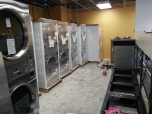 Some coin operated dryers still crated waiting to be installed in a brand new laundry.